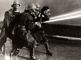 Några brandmän i arbete med gasmasker och eldproppar, 1950-60 (silvertryck av gelatin)